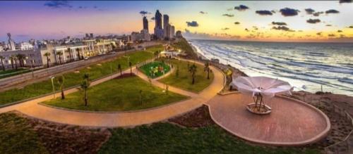 a park next to the ocean with an umbrella at Kosher for Passover Beachfront Apartment in Netanya