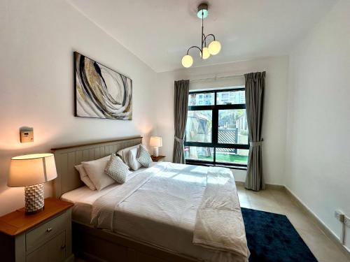 - une chambre avec un grand lit et une fenêtre dans l'établissement Lux BnB Travo Tower I Private Garden I Lake View, à Dubaï