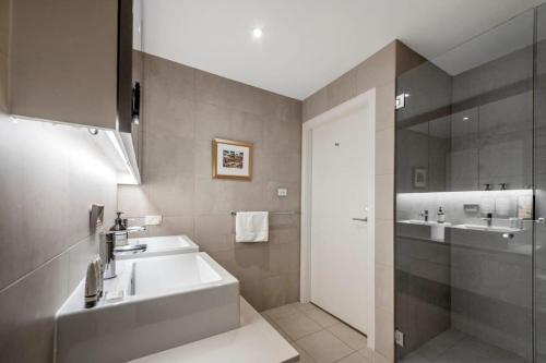 a bathroom with a sink and a tub and a mirror at Stylish City Delight In The Heart Of Canberra's Capital Hill in Kingston 