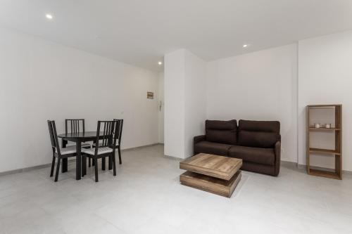 un salon avec un canapé, une table et des chaises dans l'établissement Studio proche de Béziers centre, à Béziers