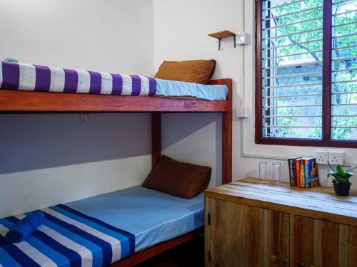 a room with two bunk beds and a desk at The White House in Trincomalee