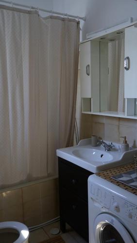 ein Badezimmer mit Waschbecken und Waschmaschine in der Unterkunft Kythneria in Kythnos