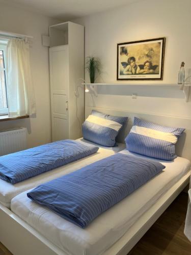 ザンクト・ペーター・オルディングにあるFerienhaus Klabautermannの- 青い枕付きのベッド2台
