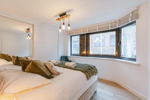 una camera da letto con un letto grande e una finestra di Huswell - Pleasant 2 bedroom apartment in city center a Blankenberge
