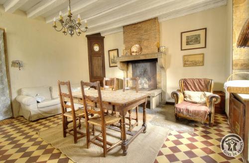 a dining room with a table and a fireplace at Domaine de Montclair in Pommiers