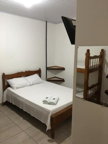 a bedroom with a bed with two towels on it at Hospedagem De Ferias in Bonito