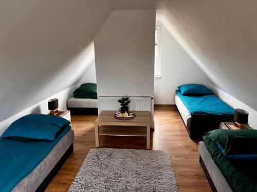 a attic room with two beds and a table at Agroturystyka „Na Wólce” in Mrągowo