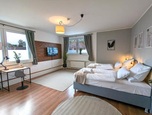 a bedroom with a bed and a desk and a television at BesTime - 5 Schlafzimmer, Wohnzimmer, Küche, Waschtrockner, Terrasse, Smart-TVs, Netflix, Tischfußball in Wildeshausen