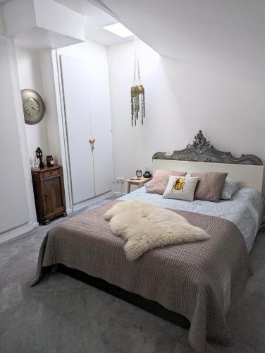 une chambre avec un grand lit avec une couverture dessus dans l'établissement Appartement de charme sous les toits avec vue sur la Garonne, à Bordeaux