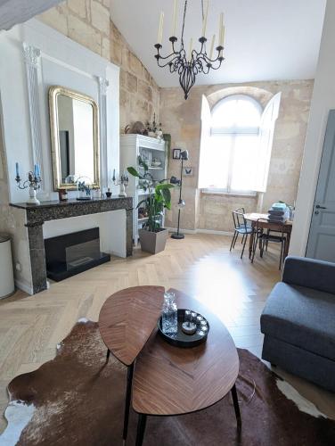 un salon avec une table et une cheminée dans l'établissement Appartement de charme sous les toits avec vue sur la Garonne, à Bordeaux
