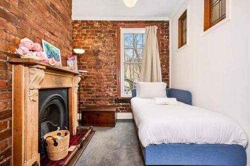 ein Schlafzimmer mit einem Bett und einer Ziegelwand in der Unterkunft Charming Fitzroy Retreat Art, Dining, Serenity in Melbourne