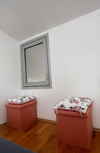 a room with two ottomans and a mirror on the wall at Goca Apartment in Skopje