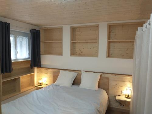 1 dormitorio con 1 cama blanca con 2 lámparas y una ventana en La Châtelaine en La Rixouse