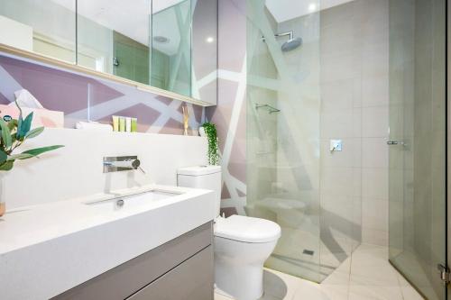 墨爾本的住宿－Stylish Urban Retreat with Spectacular Views and Prime Location，一间带卫生间和玻璃淋浴间的浴室