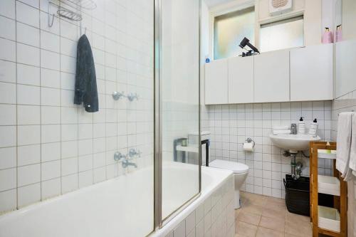 La salle de bains est pourvue d'une baignoire, de toilettes et d'un lavabo. dans l'établissement Chic Elwood 1BR Apt with Free Parking, à Melbourne