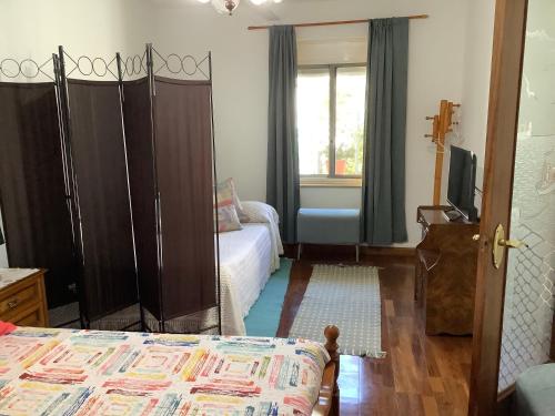 ein Schlafzimmer mit einem Bett, einem Sofa und einem Fenster in der Unterkunft Casita acogedora en el centro del pueblo in O Porriño