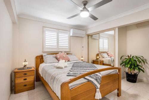 a bedroom with a large bed and a mirror at Seaside Serenity at Plumeria Place in Brisbane