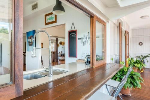 uma cozinha com um balcão de madeira e um lavatório em Homely Hideaway Bardon em Brisbane