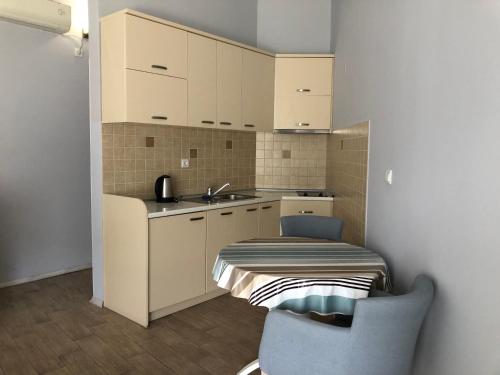 a kitchen with a sink and a table and a chair at Turquoise Beachside Apartments in Dobrota