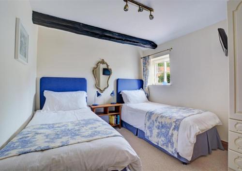 1 dormitorio con 2 camas y ventana en The Dollery en Horsham St Faith
