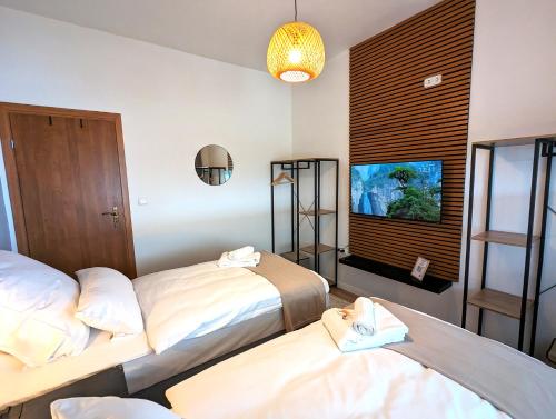 a hotel room with two beds and a flat screen tv at BesTime - 5 Schlafzimmer, Wohnzimmer, Küche, Waschtrockner, Terrasse, Smart-TVs, Netflix, Tischfußball in Wildeshausen
