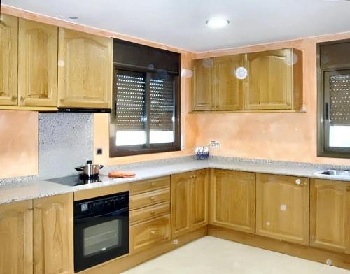uma cozinha com armários de madeira e um fogão em 4 bedrooms villa with private pool furnished terrace and wifi at Calonge em Calonge