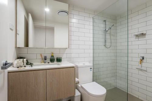 a bathroom with a toilet and a sink and a shower at Stylish Apartment with Rooftop Pool in Brisbane