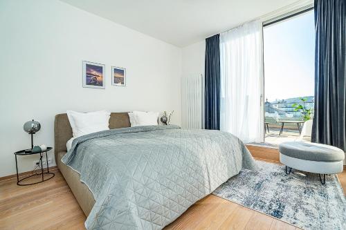 High-class rooftop apt. with spacious terrace في براغ: غرفة نوم بسرير ونافذة كبيرة