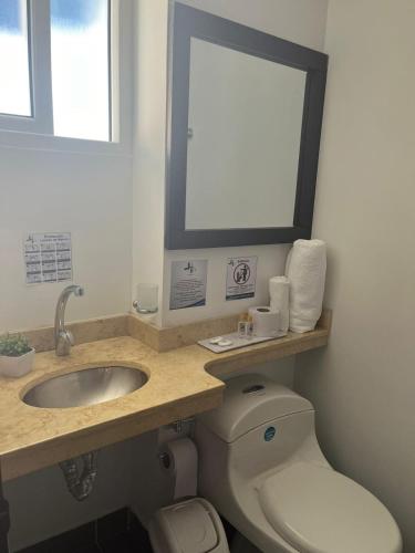 a bathroom with a sink and a toilet at Hotel H53 in Sogamoso