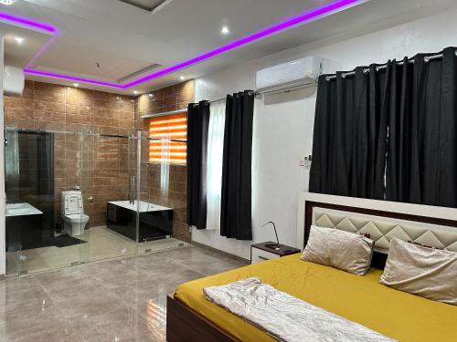 een slaapkamer met een bed en een badkamer met een douche bij Nanani Villa - Harmonious Paradise in Kumasi