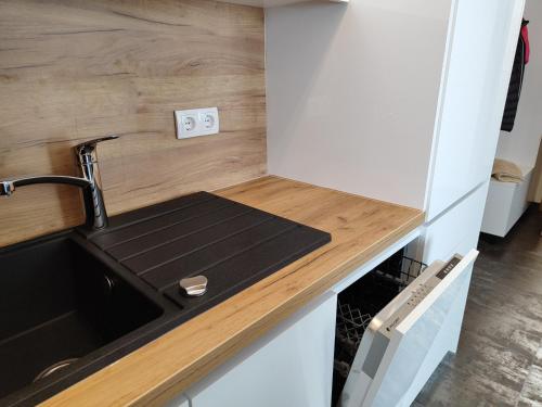 a kitchen with a sink and a counter top at Apartmani Sanja in Teslić