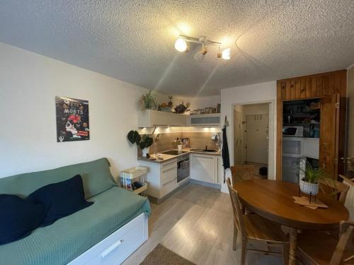 un salon avec un canapé et une table et une cuisine dans l'établissement Studio La Case de l’Écureuil, à Barcelonnette