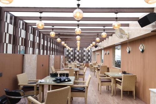 a dining room with tables and chairs and lights at HOTEL DEVA INN in Varanasi