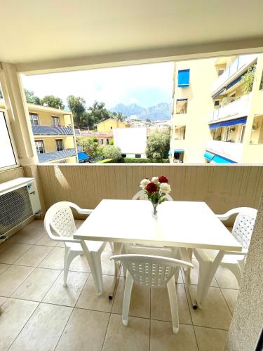 une table blanche et des chaises sur un balcon dans l'établissement L'Altezza joli T2, proche plage, terrasse, parking, à Menton