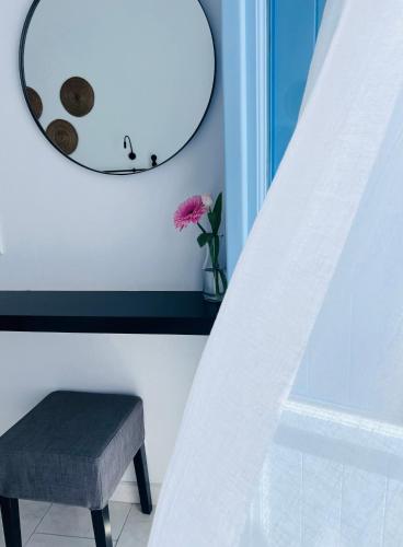a stool and a mirror in a room at Villa Fotini in Firostefani