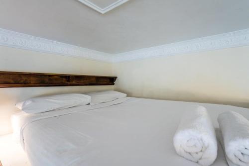 Un dormitorio con una cama blanca con toallas. en Studio in Ashgrove en Brisbane