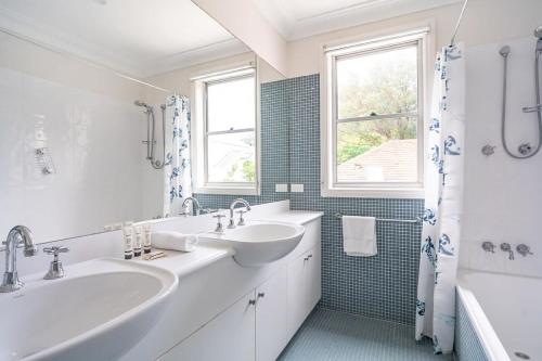 un bagno bianco con due lavandini e una finestra di Stylish Home in the heart of Newtown a Sydney