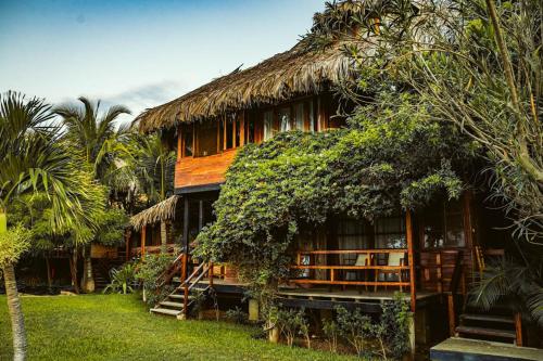 a large building with a thatched roof at Coco Ne in Máncora