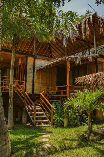 a house with a wooden staircase in front of it at Coco Ne in Máncora