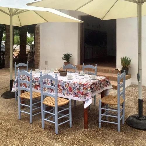 mesa con sillas y sombrilla en 7 bedrooms villa with private pool enclosed garden and wifi at Cordoba, en Córdoba