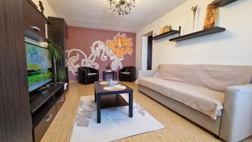 普洛耶什蒂的住宿－MMT SweetHome 2，带沙发、电视和桌子的客厅