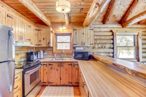 a kitchen with wooden cabinets and a stove top oven at Lakefront Park Rapids Cabin with Decks and Boat Dock! in Park Rapids
