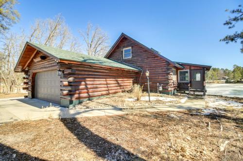 a log cabin with a garage in front of it at Lakefront Park Rapids Cabin with Decks and Boat Dock! in Park Rapids