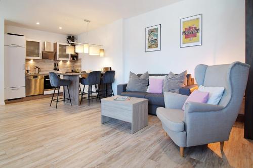 a living room with a blue couch and a kitchen at Haus Ahlbeck in Ahlbeck