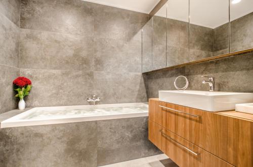 a bathroom with a sink and a bath tub at Apartamenty Prezydenckie - Morski Szum - Alldayholiday in Rogowo