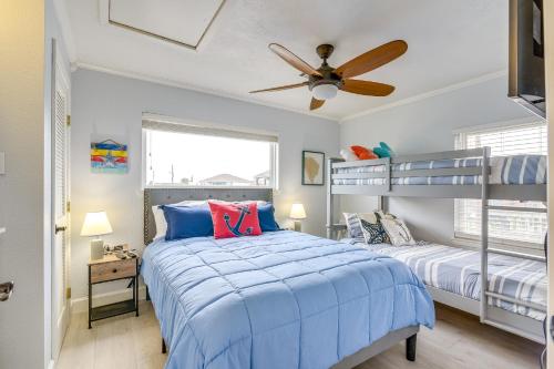 a bedroom with two bunk beds and a ceiling fan at Lovely Crystal Beach House with Deck Walk to Ocean! in Crystal Beach