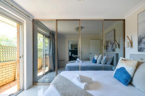 1 dormitorio con cama y espejo grande en Large Private Terrace - North Facing Terrace & BBQ, en Deewhy