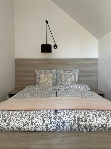 1 dormitorio con 1 cama grande con colcha blanca en Apatramenty Gaga Dębki, en Dębki