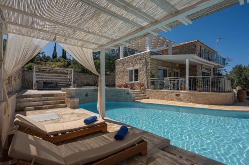 einen Pool mit einem Bett und ein Haus in der Unterkunft Louiza - Luxury Stone Villa in Volímai