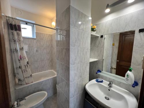 La salle de bains blanche est pourvue d'un lavabo et de toilettes. dans l'établissement Appartamento Grandis, à Gênes
